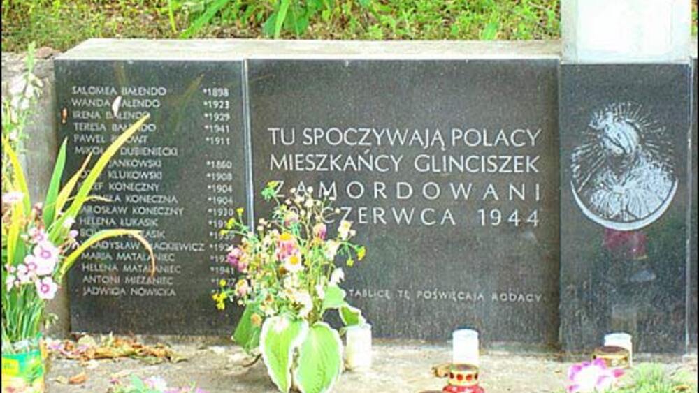 krzyż i tablica z nazwiskami na cmentarzu w Glinciszkach upamiętniająca ofiary zbrodni
