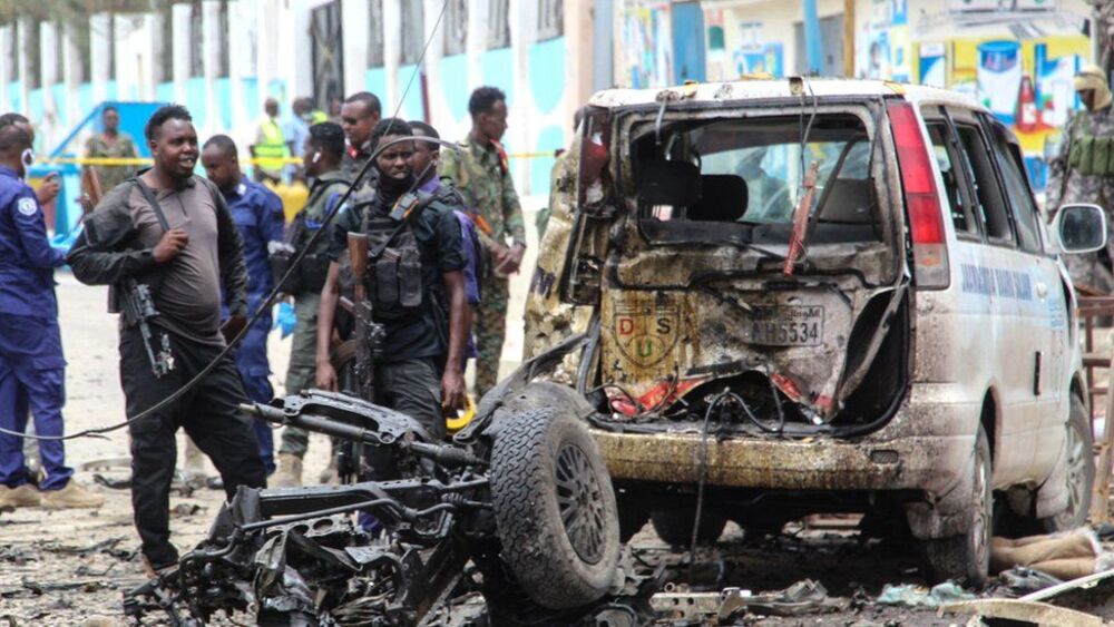 Funkcjonariusze ochrony patrolują miejsce ataku bombowego w Mogadiszu.